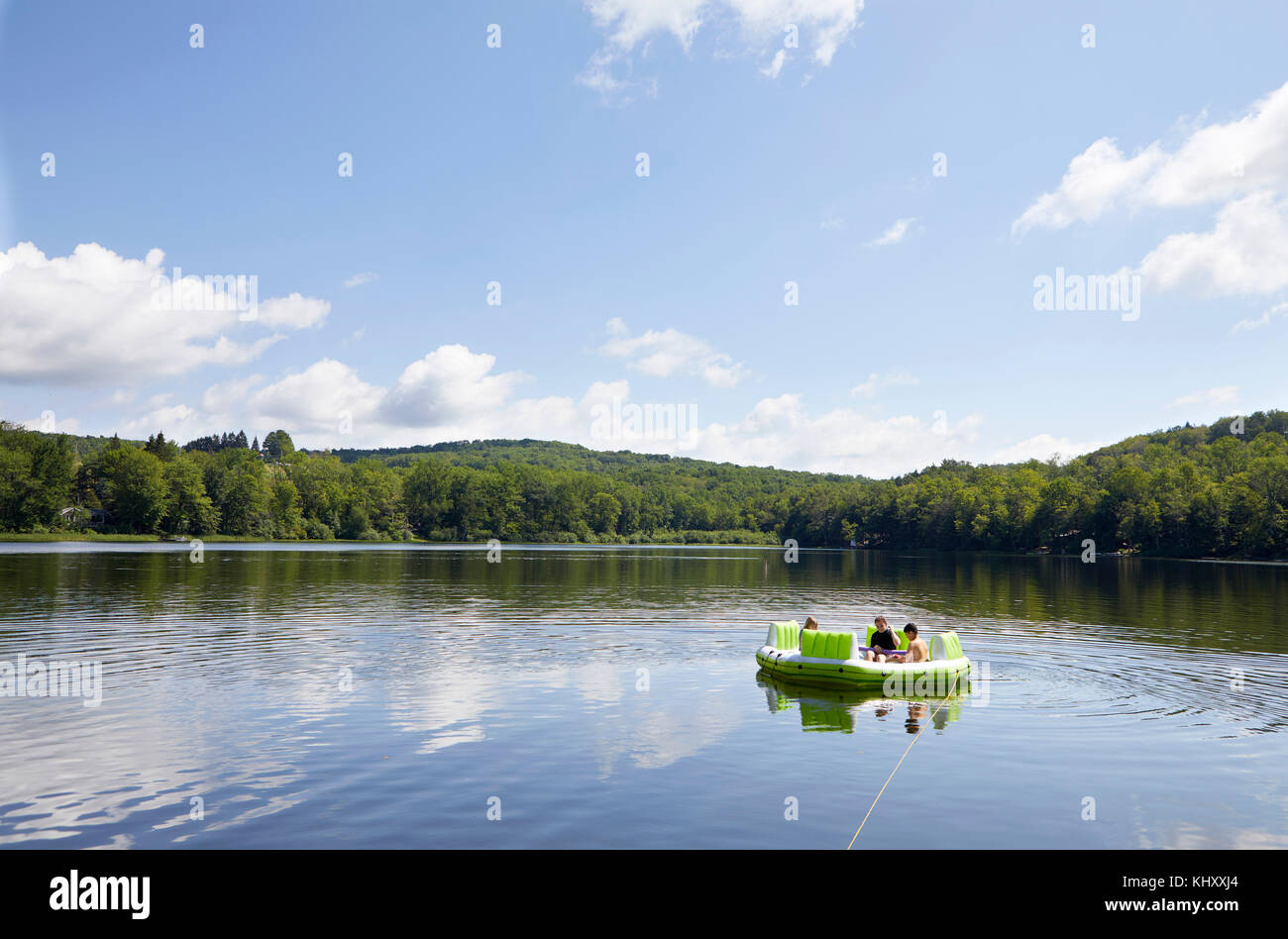 Drei Kinder auf aufblasbaren Boot auf See Stockfoto