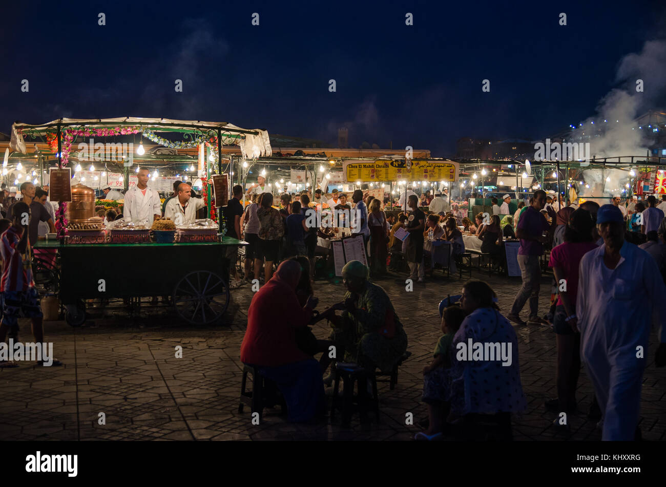 Marrakesch, Marokko - 05. September 2013: Essen steht mit Rauch und Licht auf dem berühmten Platz Djemaa el-Fna in Abend Stockfoto