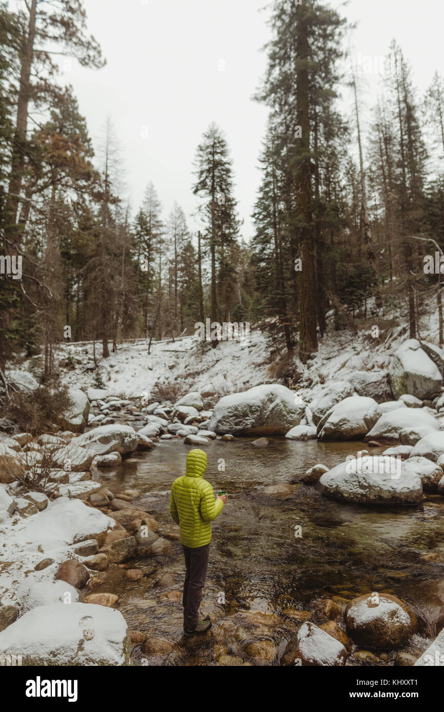 Ansicht der Rückseite des männlichen Wanderer mit Blick auf den Fluss im verschneiten Sequoia National Park, Kalifornien, USA Stockfoto