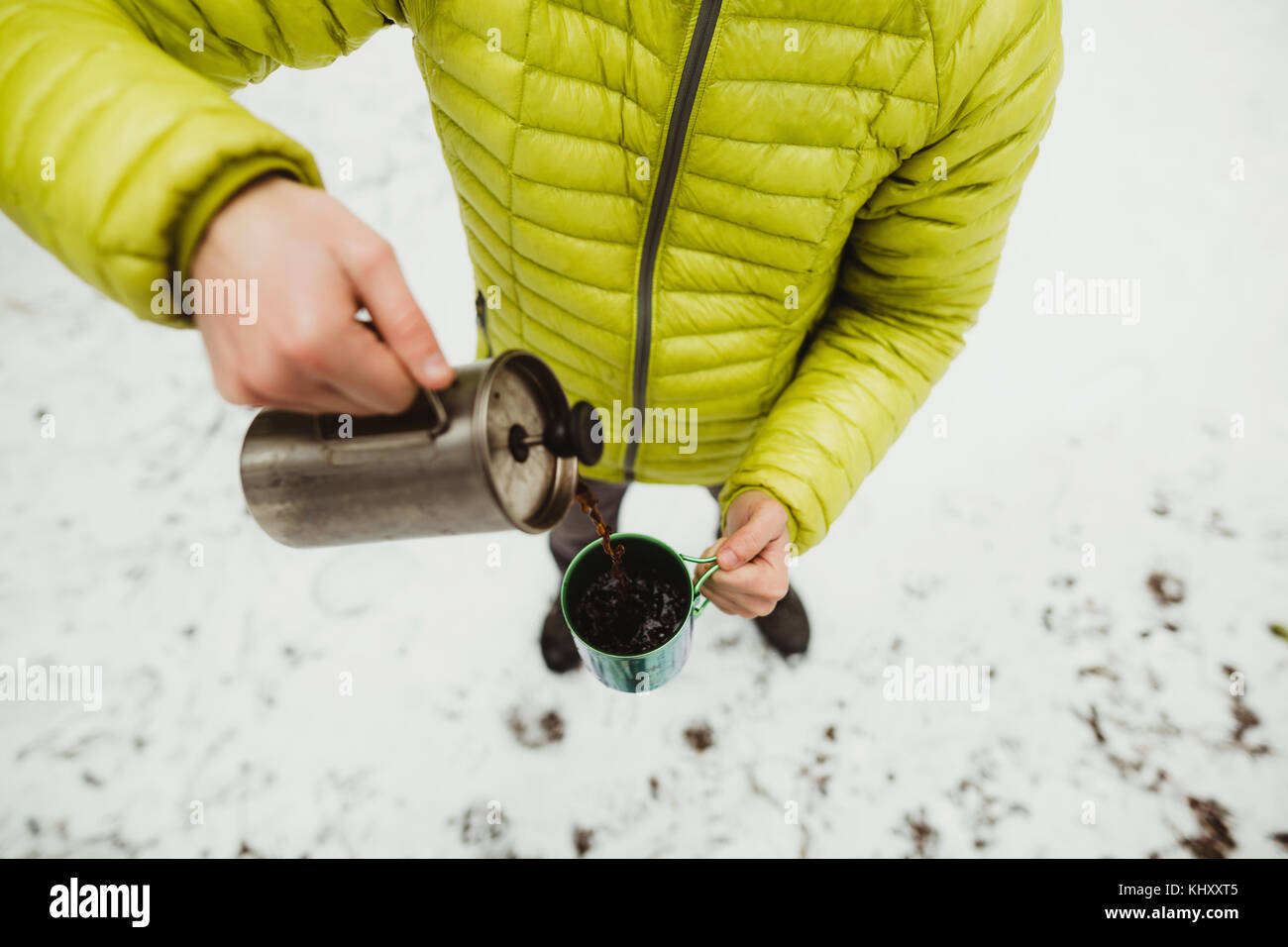Hohen winkel Hals nach unten an der männlichen Wanderer Kaffee Gießen von Kolben im Schnee Stockfoto