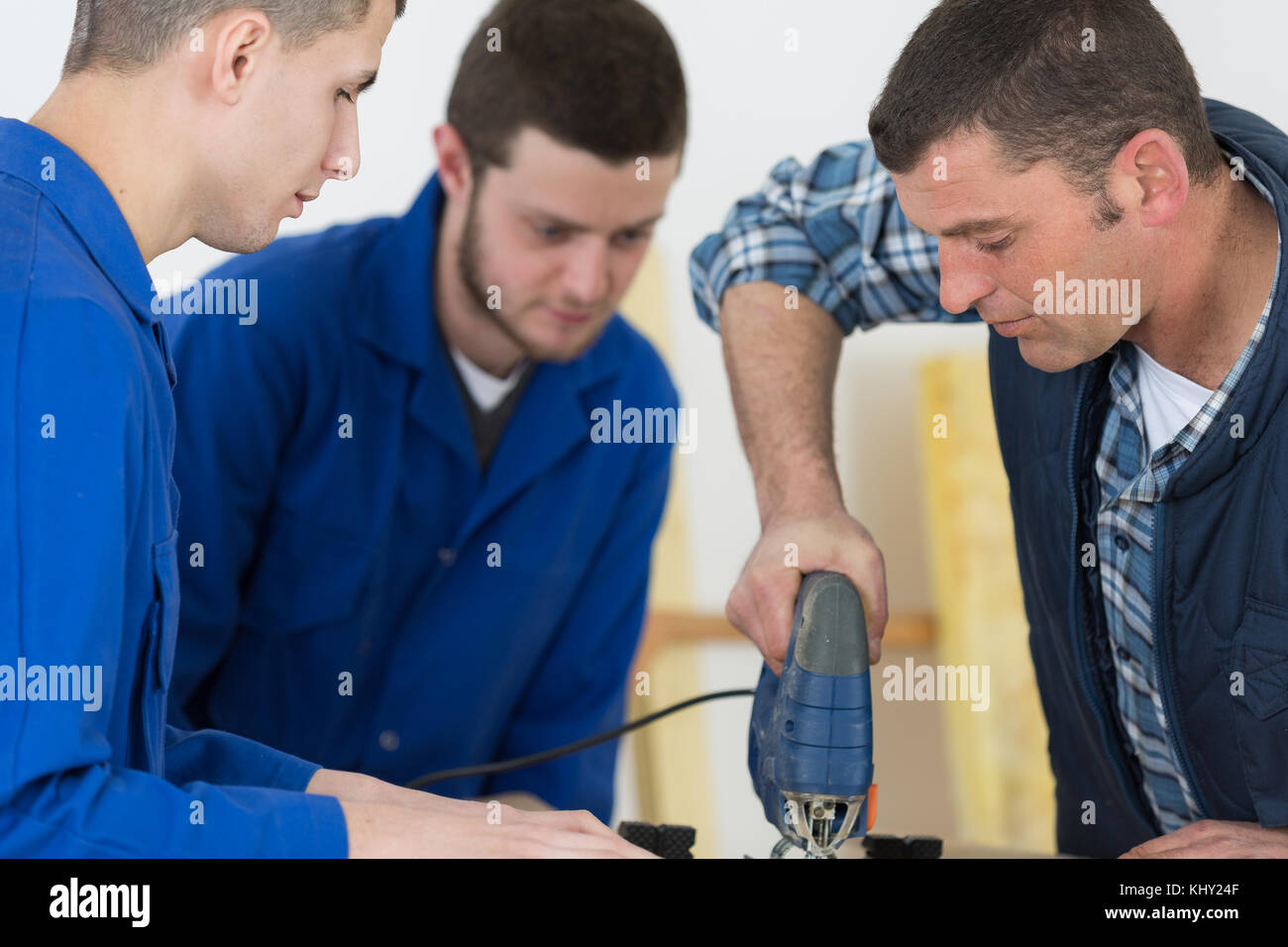 Junge Arbeiter in Schutzkleidung Arbeitskleidung Schneiden von Metall in der Industrie Stockfoto