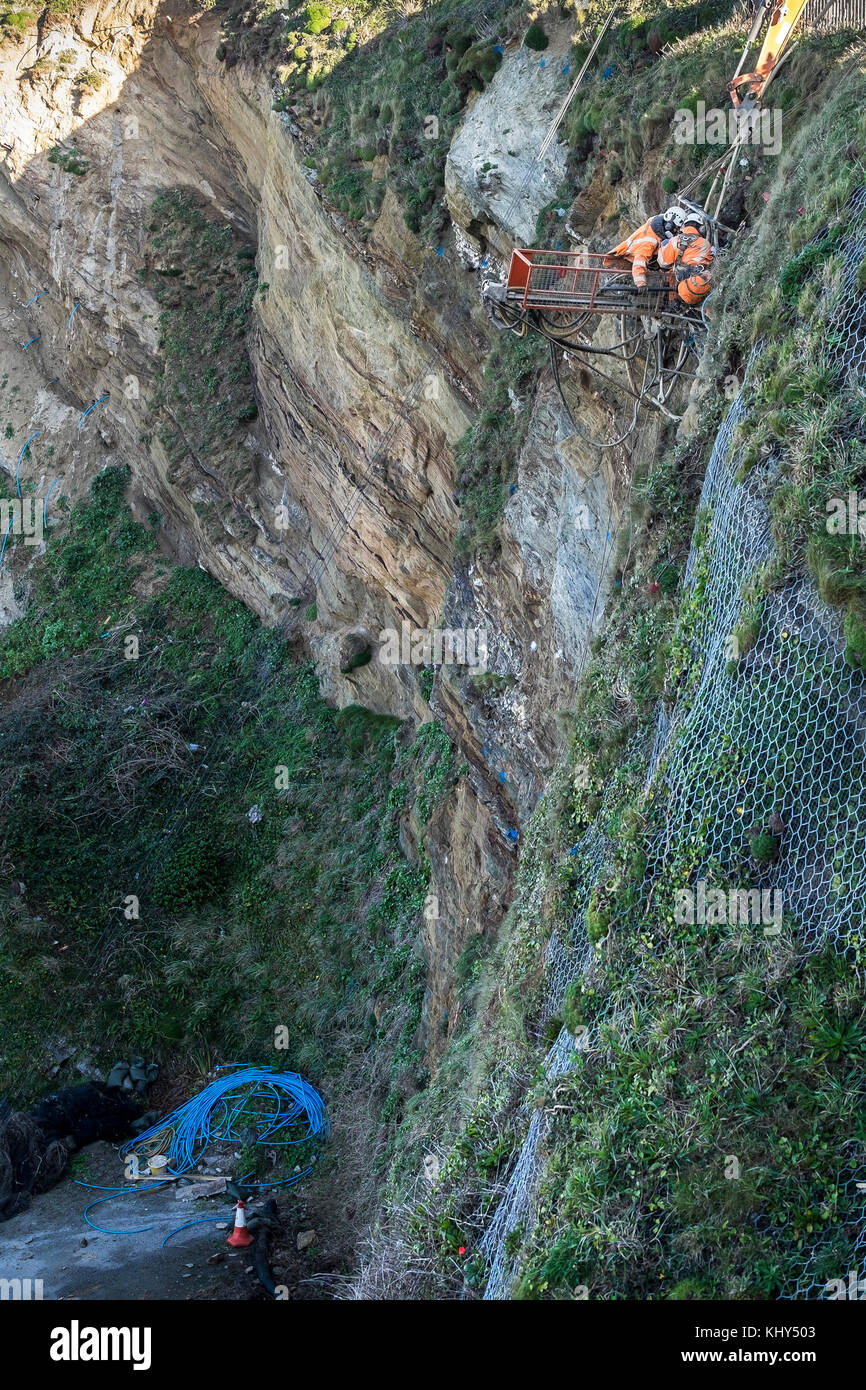 Zwei Arbeiter Bohren von Löchern in einem instabilen Klippe über Tolcarne Beach in Newquay Cornwall im Vereinigten Königreich. Stockfoto