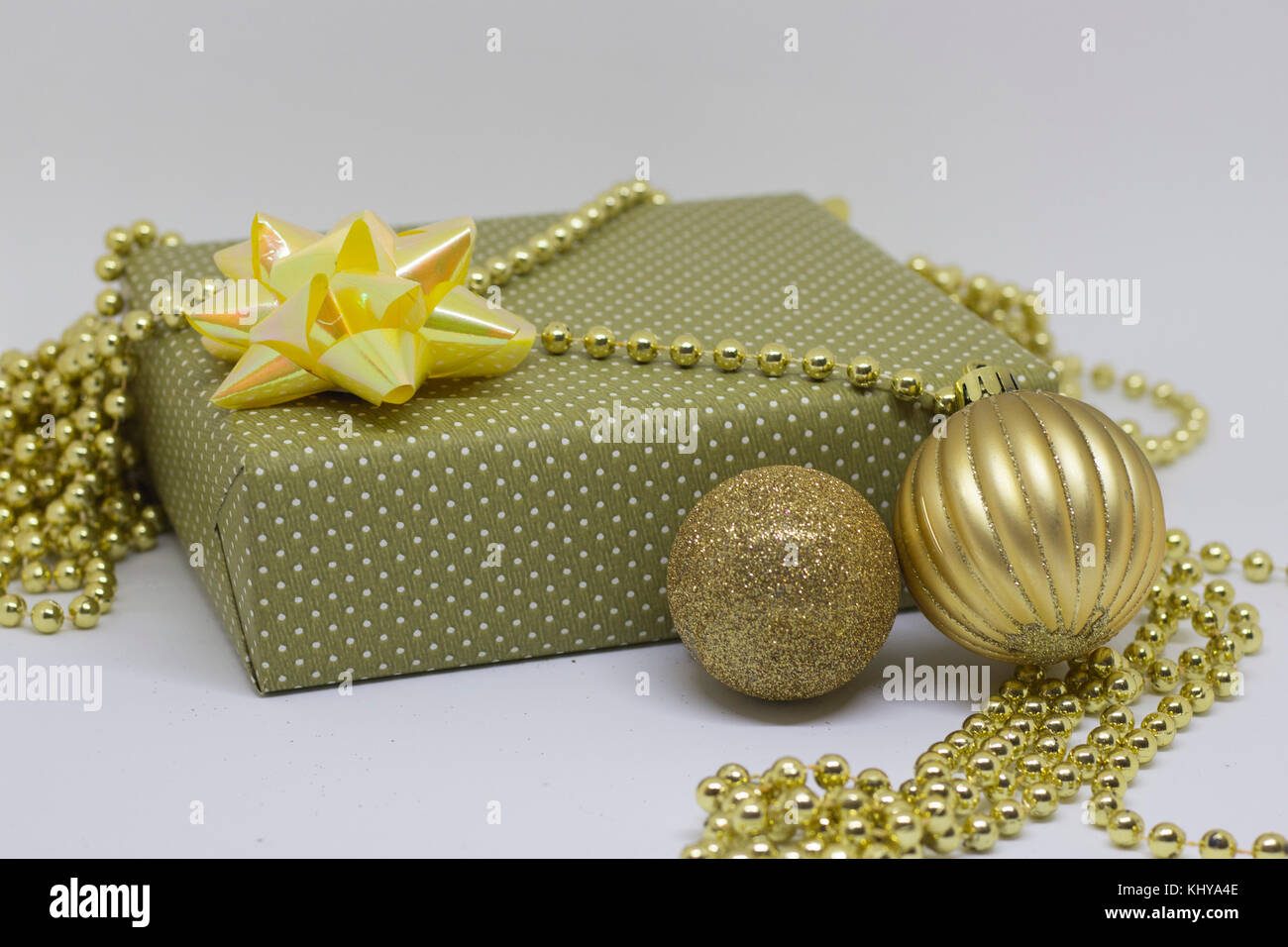 Geschenkbox und zwei Weihnachten Kugeln auf einem hellen Hintergrund Stockfoto