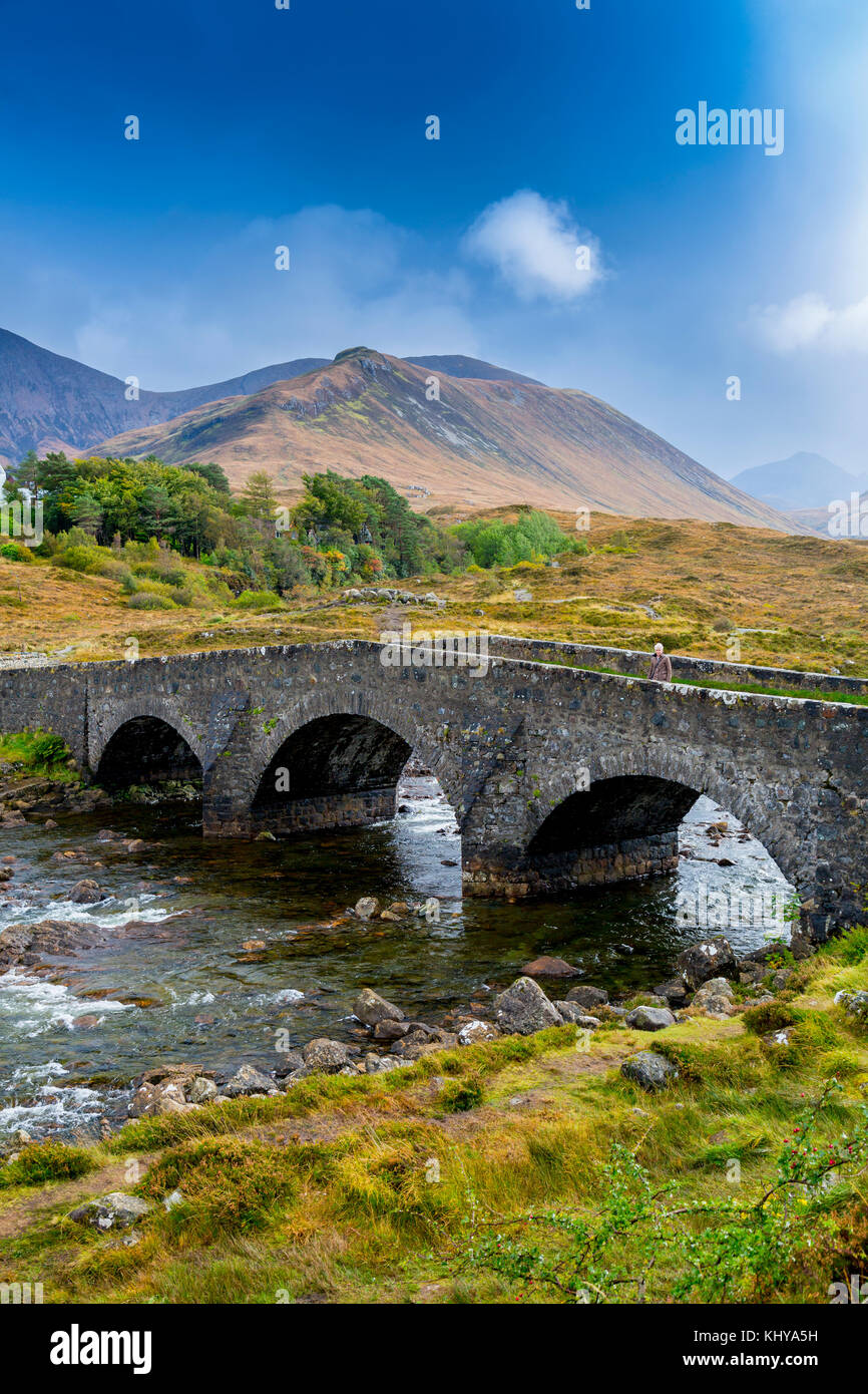 Eine alte Straße Brücke über den Fluss und die einsamen Sligachan Red Cuillin Hills in der Nähe von Sligachan, Isle of Skye, Schottland, Großbritannien Stockfoto