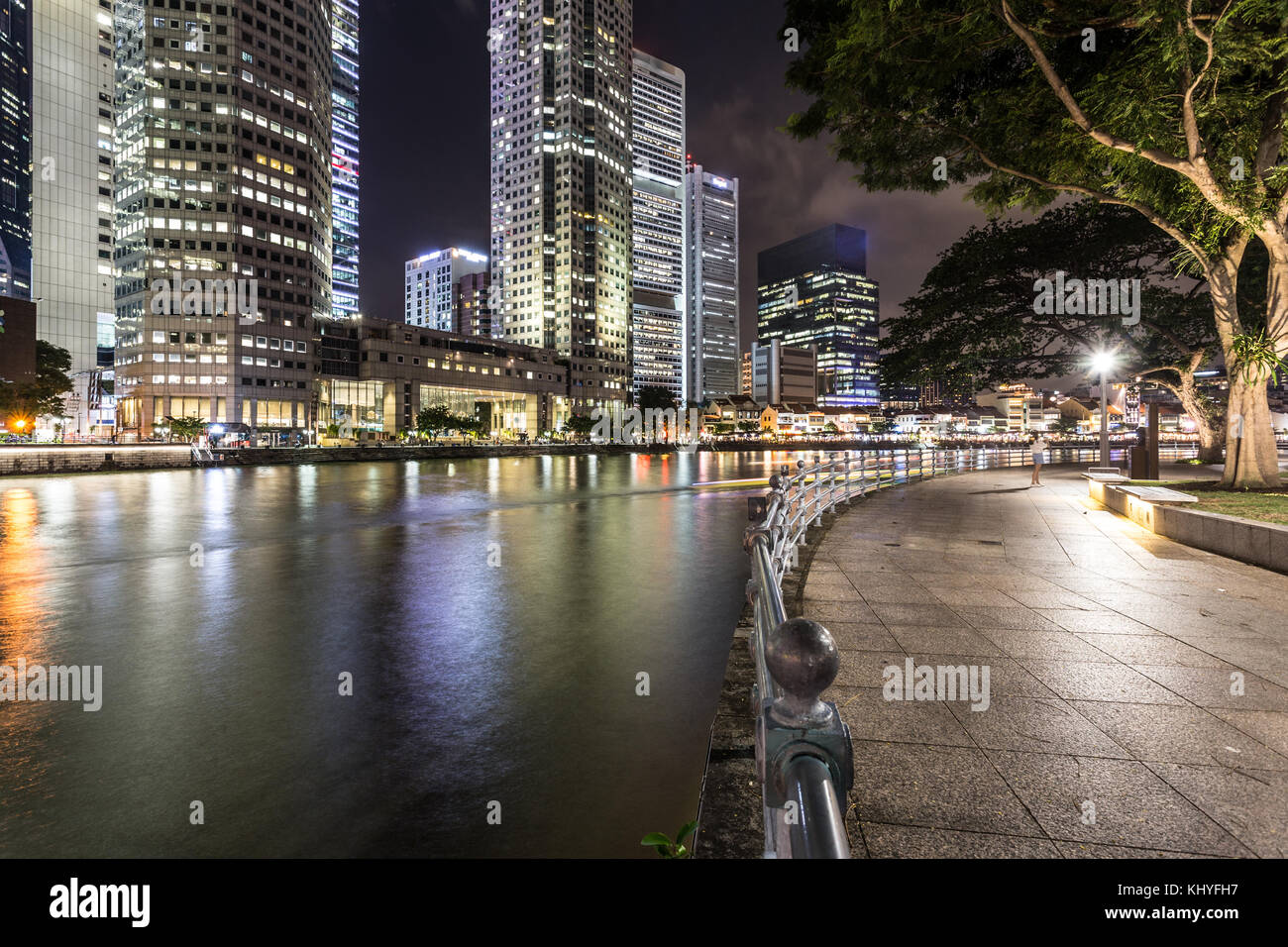 Die Lichter der Wolkenkratzer des Financial District spiegeln sich im Wasser des Singapore River entlang der Jubiläums Spaziergang bei Nacht in Singapur, Süd Stockfoto