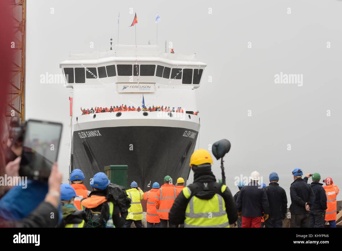 Port Glasgow, Schottland, Großbritannien. Nov. 2017. Die Öffentlichkeit, Hafenarbeiter und Schiffsbauer der Ferguson Marine in Port Glasgow beobachten im strömenden Regen als Erster Minister, Nicola Sturgeon startet die Autofähre Glen Sannox auf dem Fluss Clyde. Stockfoto