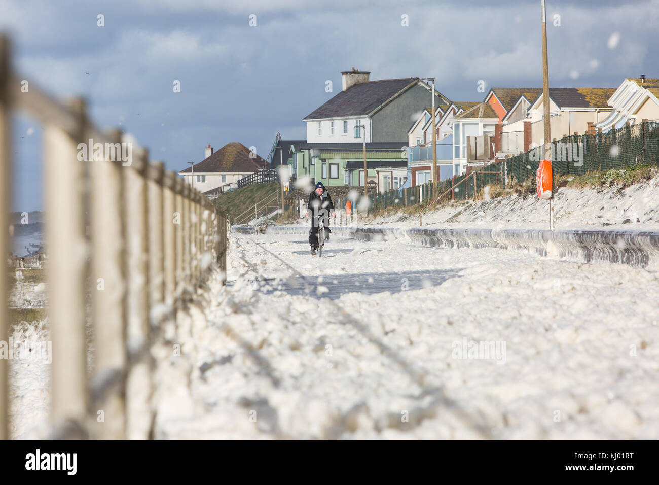 Tywyn, Großbritannien. 23 Nov, 2017. de Wetter. ein Mann Zyklen durch Sea Foam, deckt das Meer in tywyn, in der Nähe von Aberdovey, den Eindruck zu erwecken, dass es schneit wurde. Quelle: Jon Freeman/alamy leben Nachrichten Stockfoto