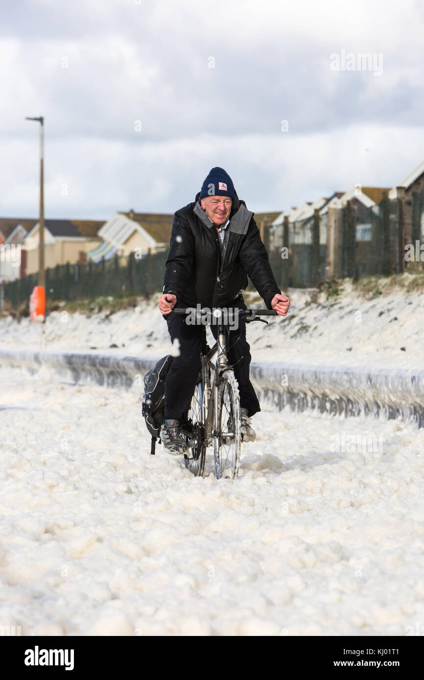 Tywyn, Großbritannien. 23 Nov, 2017. de Wetter. ein Mann Zyklen durch Sea Foam, deckt das Meer in tywyn, in der Nähe von Aberdovey, den Eindruck zu erwecken, dass es schneit wurde. Quelle: Jon Freeman/alamy leben Nachrichten Stockfoto