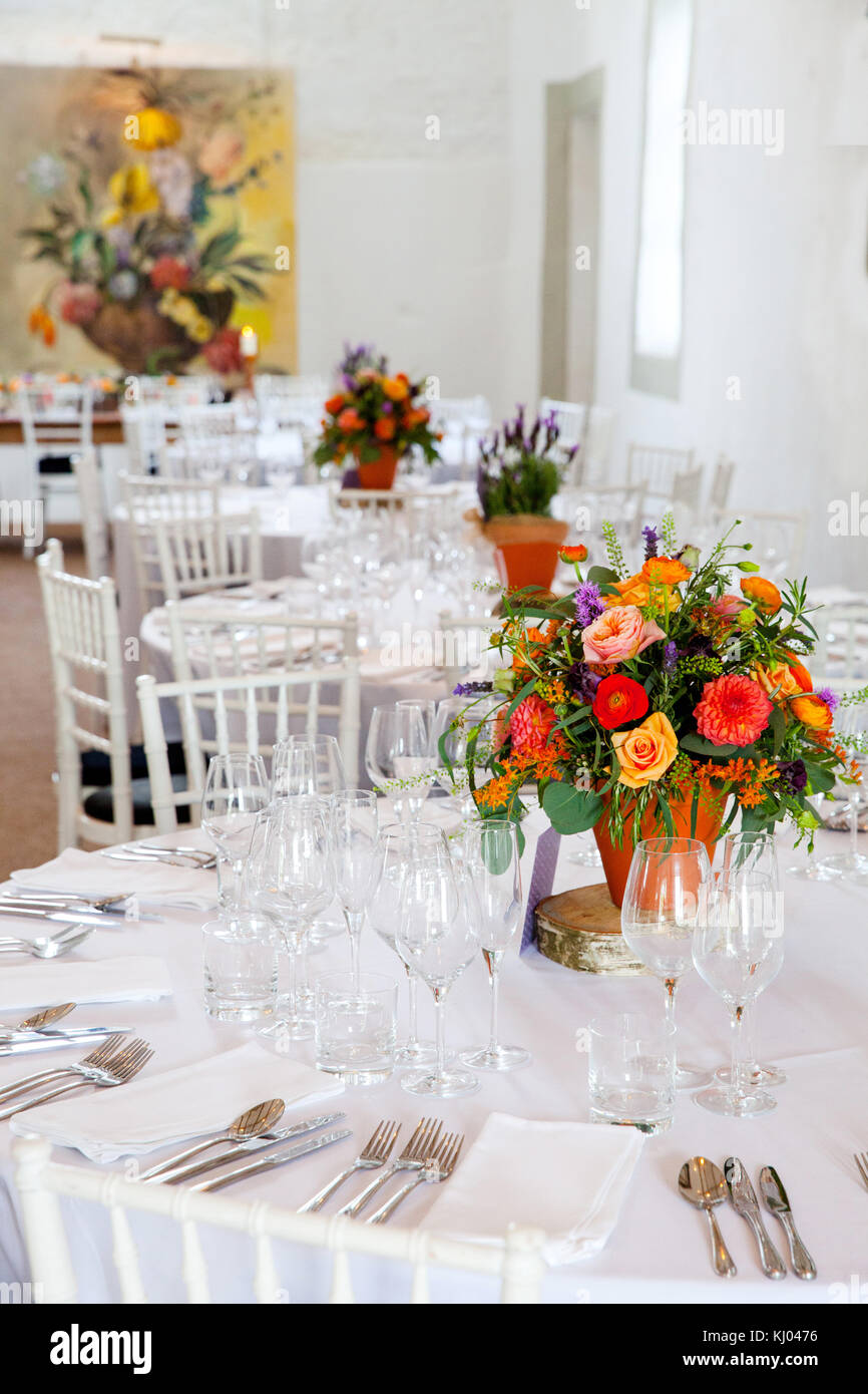 Hochzeit Tabellen mit Einstellungen und farbenfrohe Blumenarrangements Stockfoto