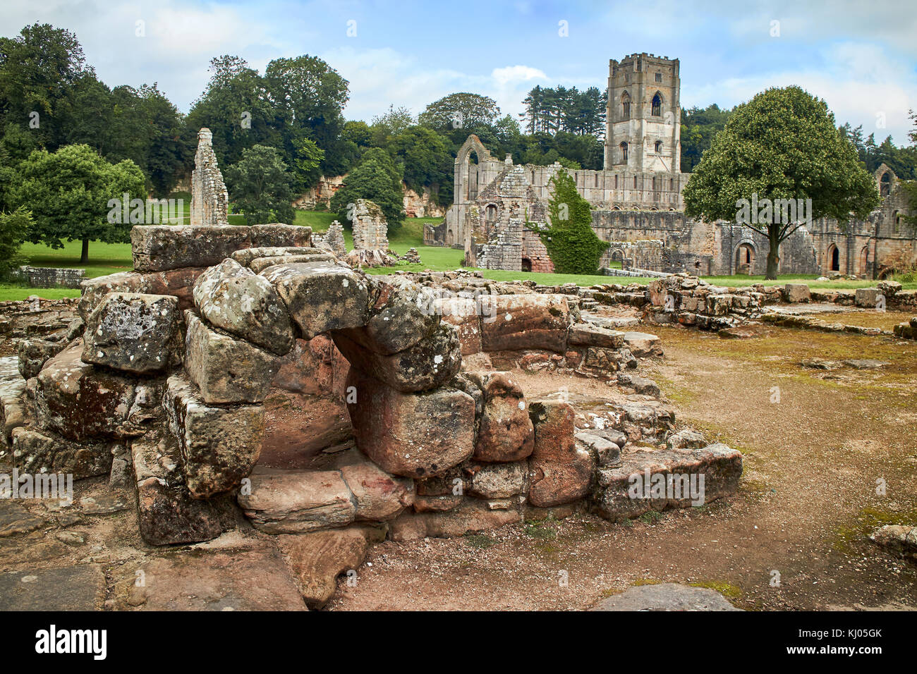 England, NorthYorkshire; die Ruinen des 12. Jahrhunderts Zisterzienserabtei als Fountains Abbey, eines der schönsten Beispiele der klösterlichen Architektur in der Welt bekannt. Der Turm von Abt Huby, (1495-1526), dominiert das Tal noch Landschaft. Zusammen mit seinen umliegenden 800 Morgen des 18.Jahrhunderts angelegten Parklandschaft, Fountains Abbey wurde von der UNESCO zum Weltkulturerbe ernannt. North Yorkshire, England, UK. Ca. 1995. | Lage: in der Nähe von Bedale, Yorkshire, England, UK. Stockfoto