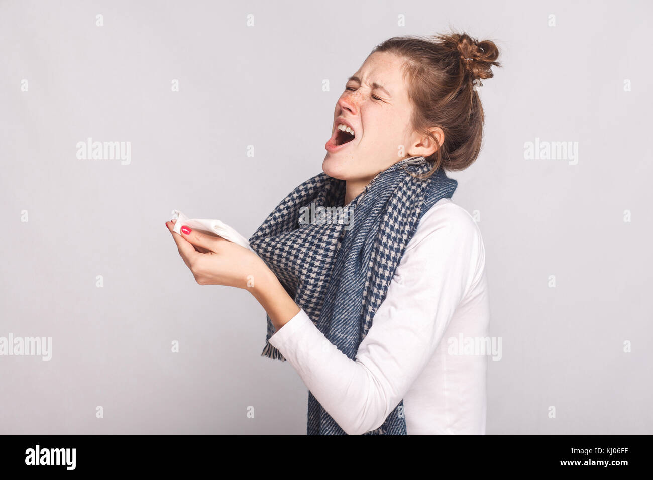 Kranke Frau hält ein Taschentuch und Niest. indoor Schuß Stockfoto