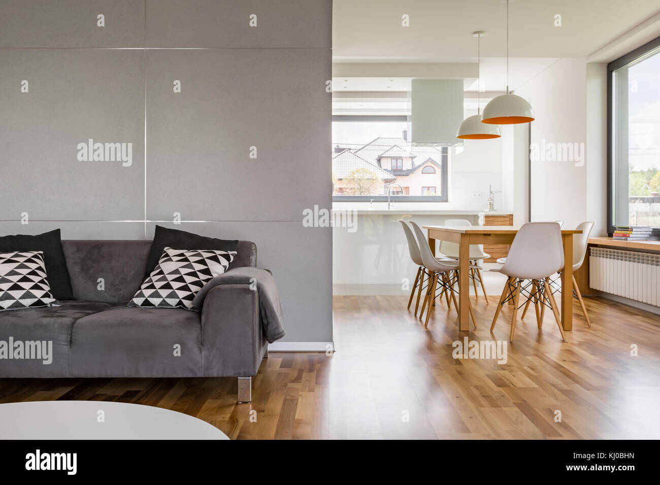 Wohneinrichtung mit grauer Couch, Holztisch und modernen Lampen Stockfoto