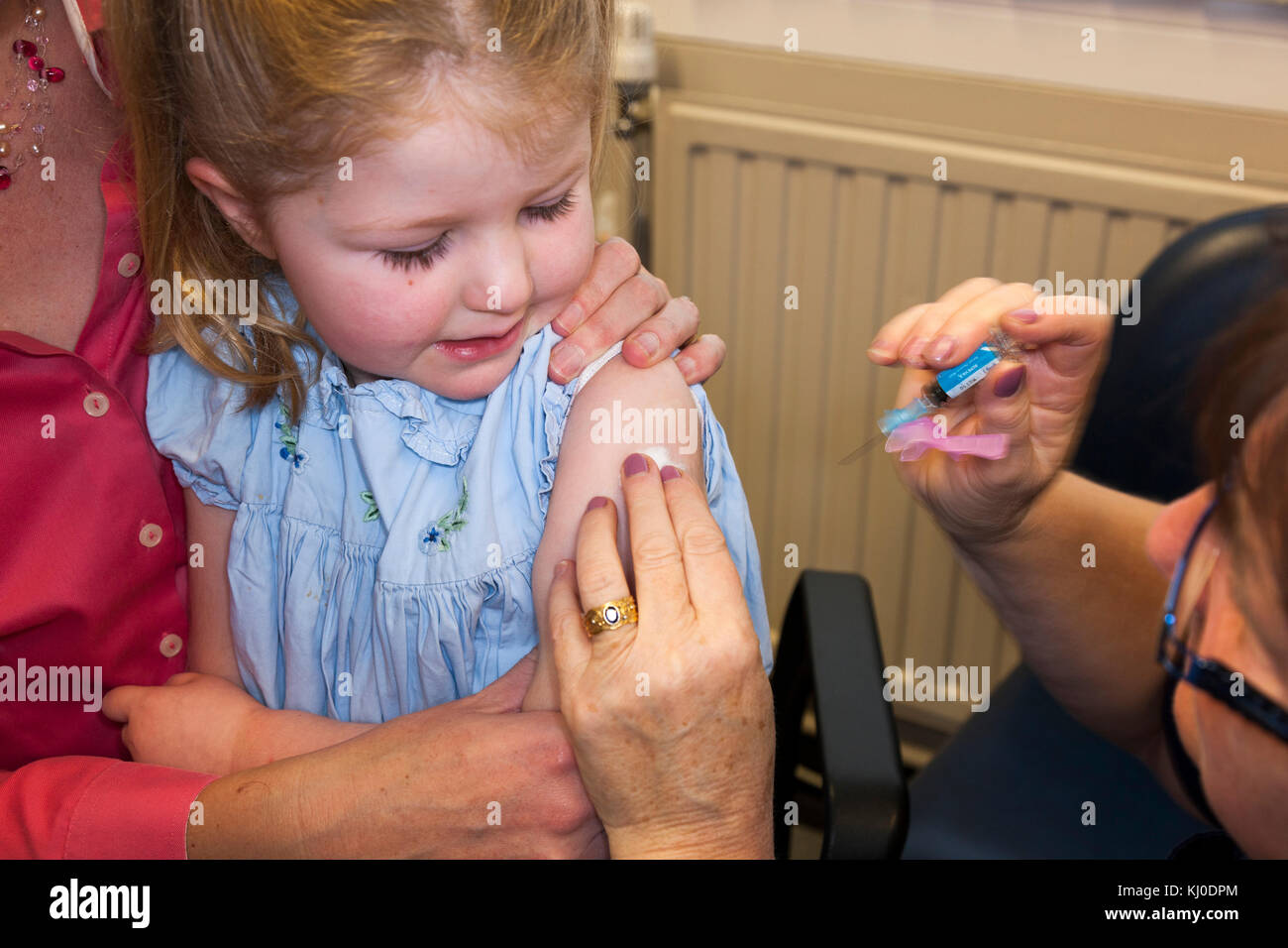 Praxis Krankenschwester, NHS 4-in-1-Pre-school Booster/Pre school Booster & MMR zweite Dosis Immunisierung/Impfung/Jab zu 3 drei Jahre altes Kind Stockfoto
