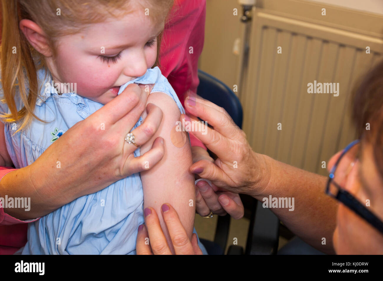 Praxis Krankenschwester, NHS 4-in-1-Pre-school Booster/Pre school Booster & MMR zweite Dosis Immunisierung/Impfung/Jab zu 3 drei Jahre altes Kind Stockfoto
