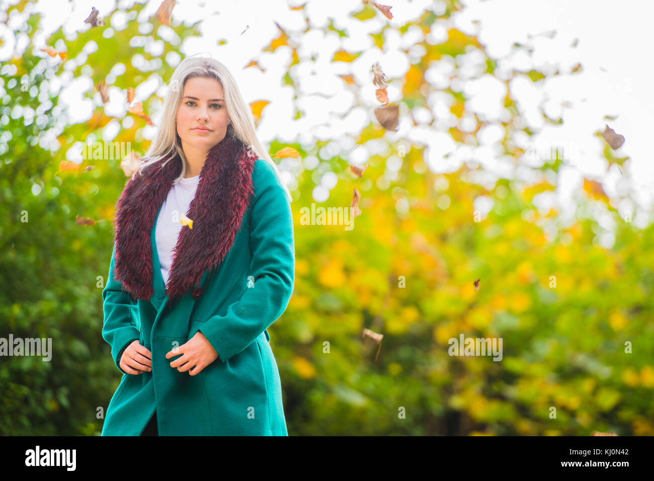 Jugendmädchen Modellierung in Großbritannien: Eine junge 16 jährige Pubertierende, trug einen Pelzbesatz grünen Mantel, modeling Posing im Freien an einem Herbsttag, Großbritannien Stockfoto
