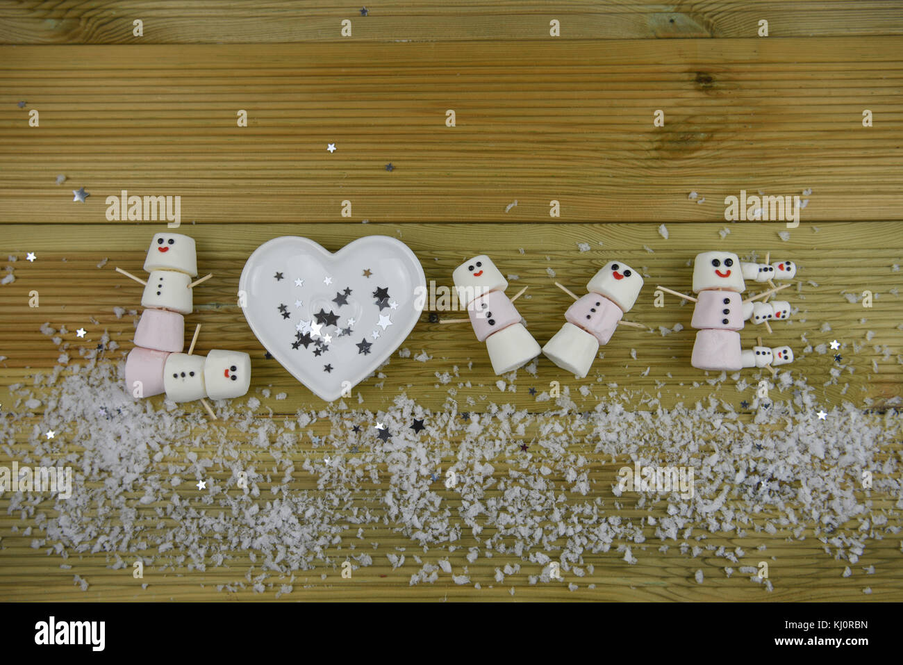 Winter fotografie Bild mit dem Wort Liebe in Marshmallows so glücklich Schneemann mit Iced auf Lächeln geformten geschrieben und bestreut mit Schnee Stockfoto