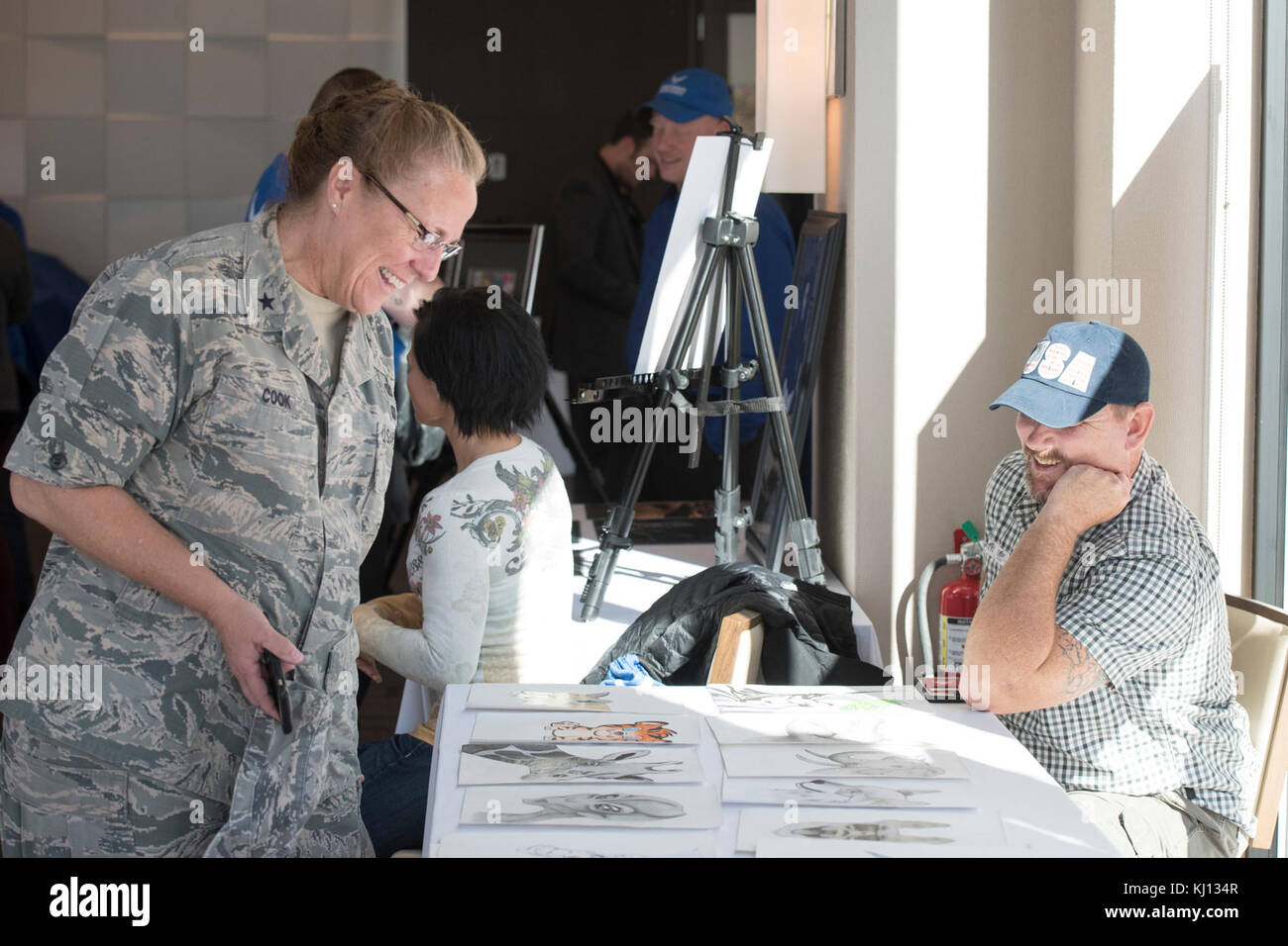 Brigadegeneral Kathleen A. Koch, Geschäftsführer der Air Force Services, Gespräche mit Veteran Bryce Keene über sein Kunstwerk bei "Ein Tag der Heilenden Künste: von Klinik zu Gemeinschaft", eine Veranstaltung zu Ehren der Bedeutung der heilenden Künste, während Krieger Care Monat am Nationalen Hafen in Oxon Hill, Maryland am 16. November 2017. (DoD Foto von Roger L. Wollenberg) Stockfoto