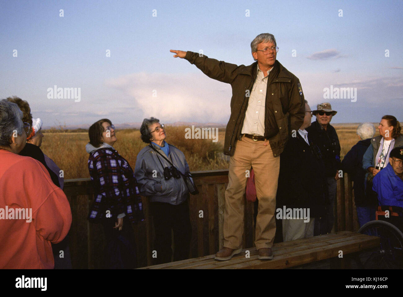 Ein Manager spricht Besucher einer öffentlichen Einrichtung oder eines Unternehmens an und bietet Einblicke oder Ratschläge zu Dienstleistungen und Abläufen. Stockfoto