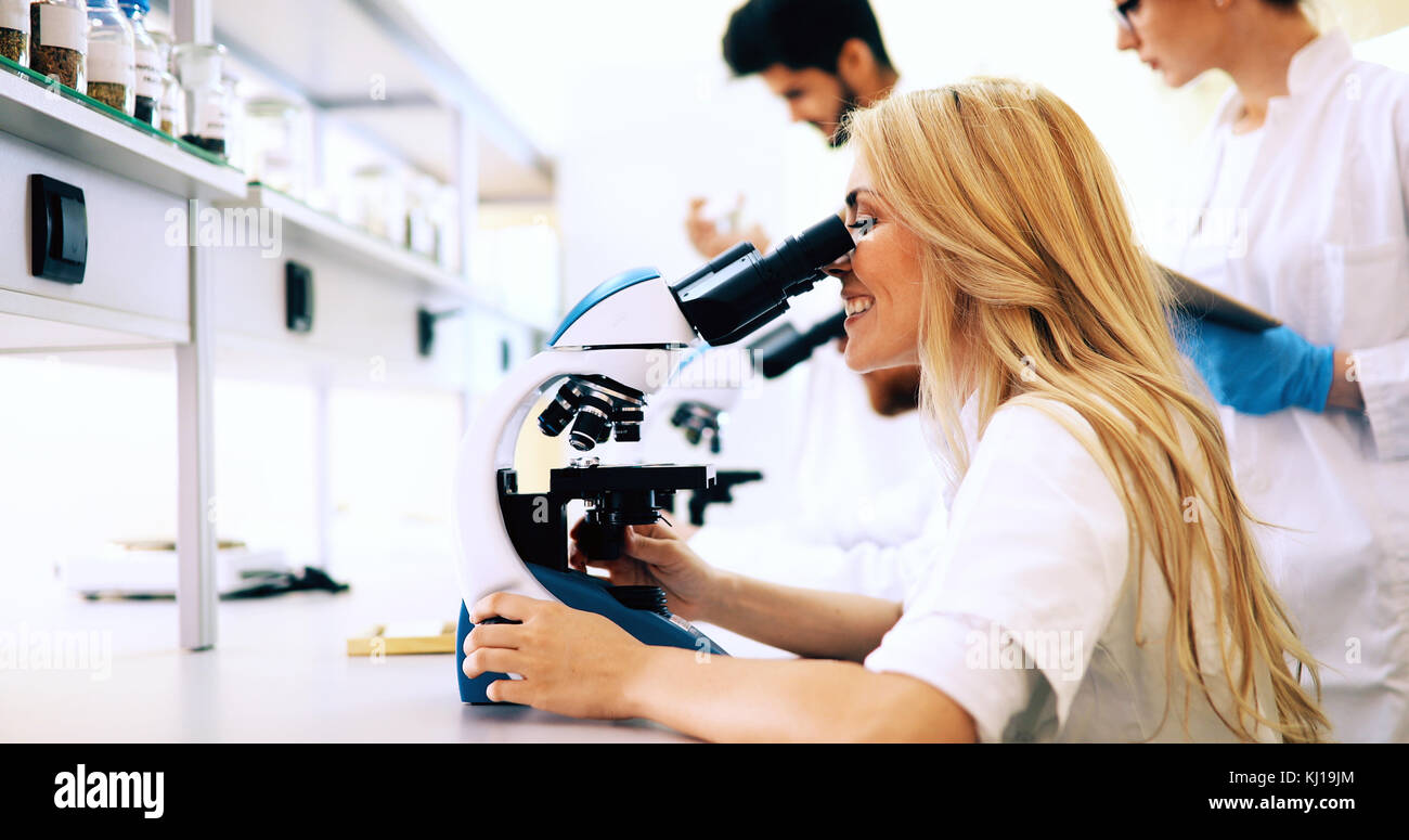 Gruppe von Wissenschaftlern für die Forschung durch Mikroskop Stockfoto