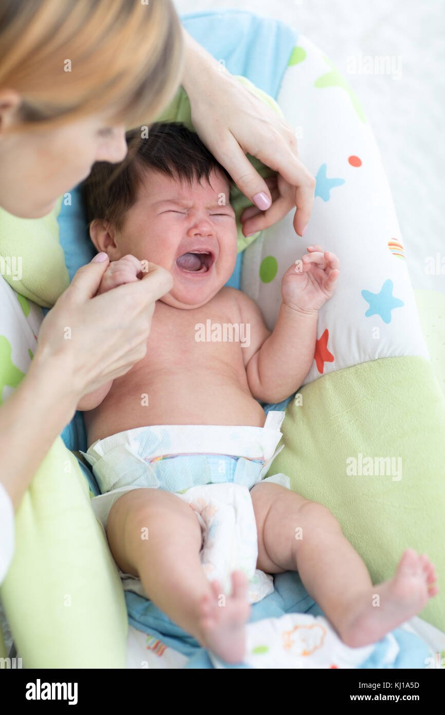 Mutter beruhigt neugeborenes Baby. Kind weinen und schreien während Kolik Stockfoto
