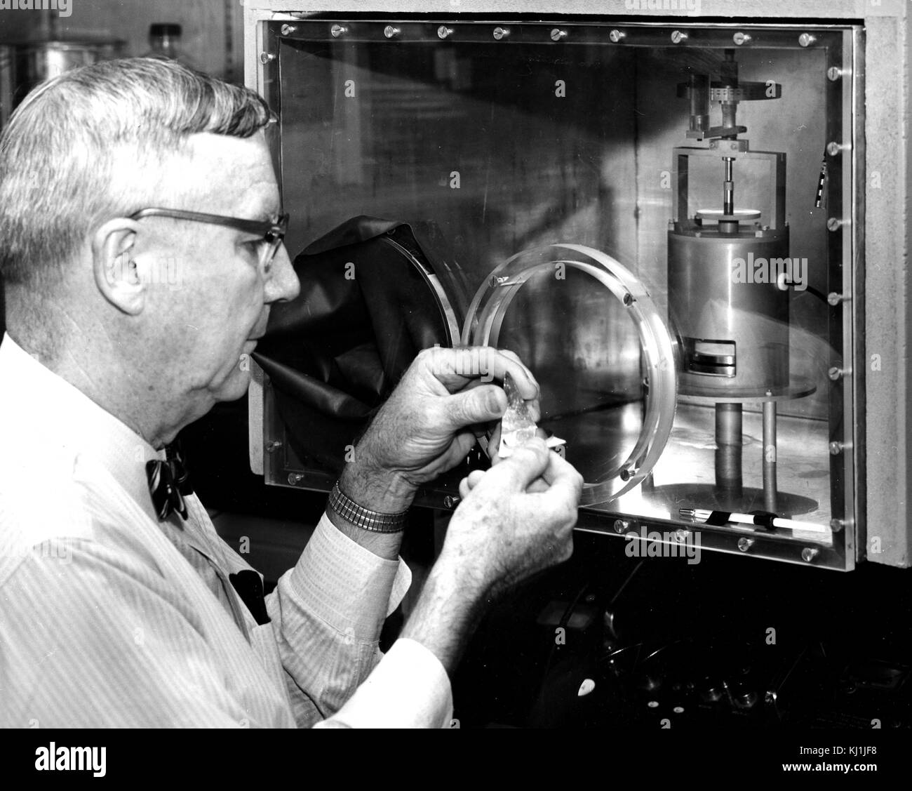 Foto von einem Physiker mit einem geschlossenen respirometer Überwachung ein komplexes Experiment. Ein respirometer ist ein allgemeiner Begriff, umfasst eine Reihe von Techniken, die für die Schätzungen der Metabolismus der Wirbeltiere, Wirbellose, Pflanzen, Gewebe, Zellen oder Mikroorganismen über ein indirektes Maß der Wärmeerzeugung. Vom 20. Jahrhundert Stockfoto