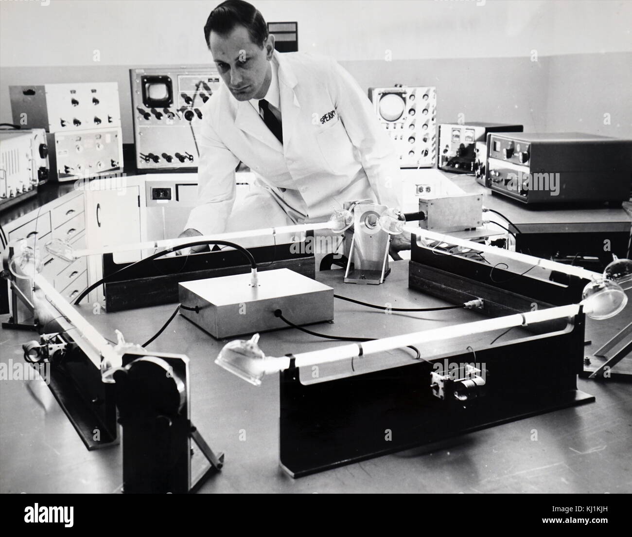 Foto von einem Wissenschaftler testen eines "closed-circuit "Laser, Superior, ein gyroskop Für die Führung der Raumfahrzeuge, Raketen, Flugzeuge und Schiffe. Laserlicht Balken blinken durch die vier Leuchtstoffröhren in entgegengesetzte Richtungen werden verwendet, um kleine Bewegungen des Labor Tabelle zu messen. Vom 20. Jahrhundert Stockfoto