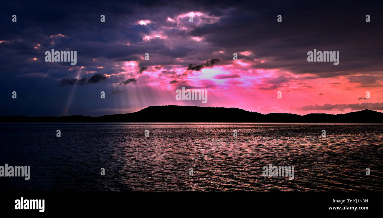 Herrlich inspirierend Bunten trübe Wasser Panoramablick sonnenaufgang Seascape mit markanten Sonnenstrahlen mit Ozean Wasser spiegeln Stockfoto