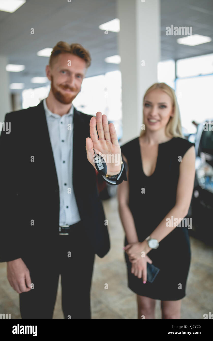 Schönes Paar im Fahrzeug showroom Holding Keys von neuen Autos. Stockfoto