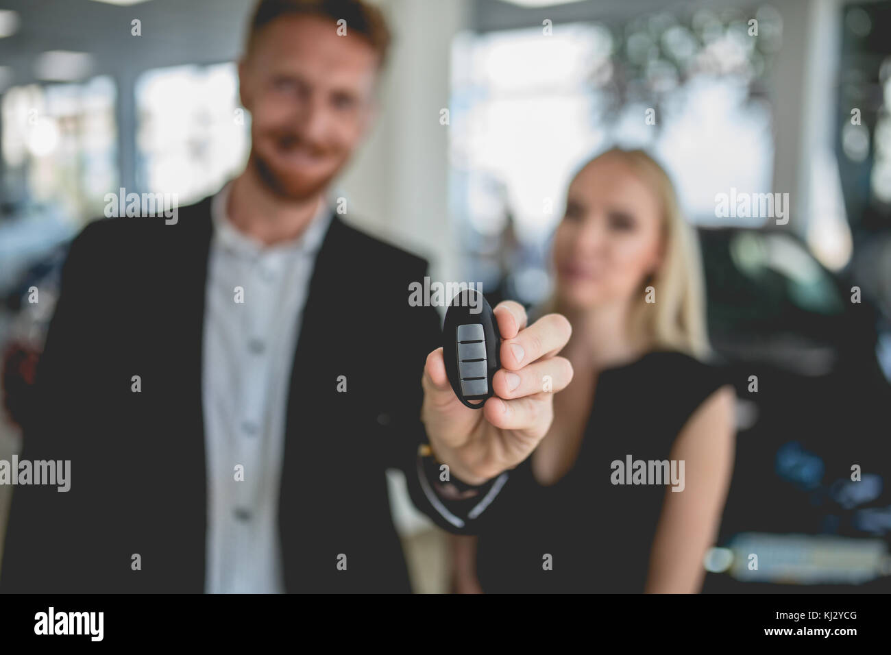 Junges Paar mit Schlüssel aus neuen Elektro Auto. Stockfoto