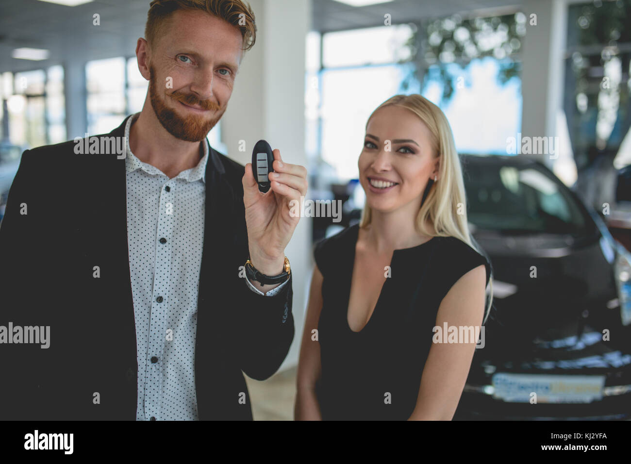 Glückliche junge Mann hält den Schlüssel aus dem neuen Auto. Stockfoto