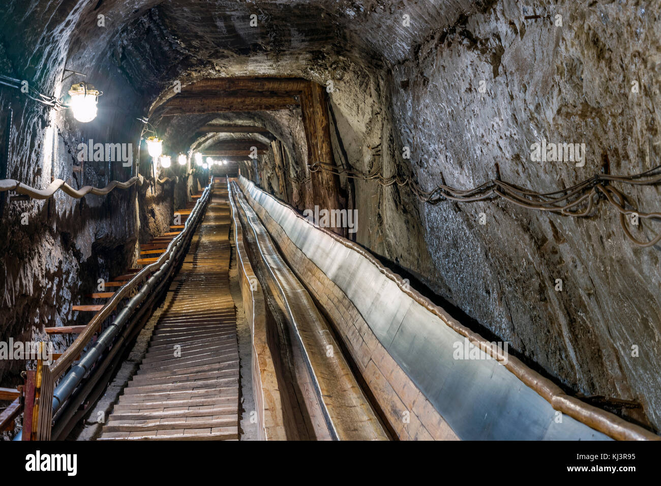 Riemen conveyot in beleuchteten unterirdischen Tunnel im Salzbergwerk Stockfoto