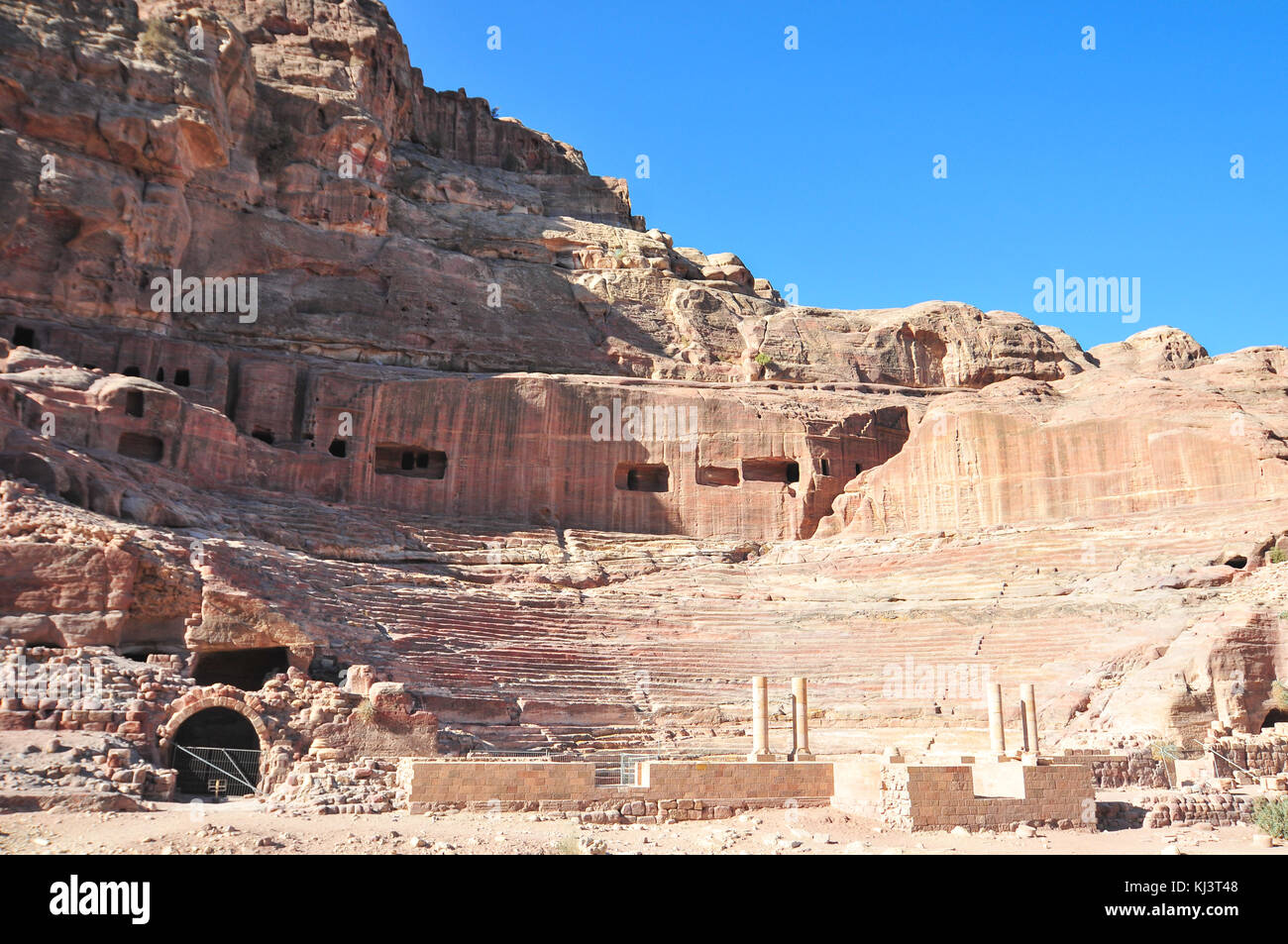 Der römischen Ära Amphitheater in die rosa Sandstein an Petra, Jordanien. die Fassaden in den Felsen gehauenen hinter sind alte Gräber. Stockfoto