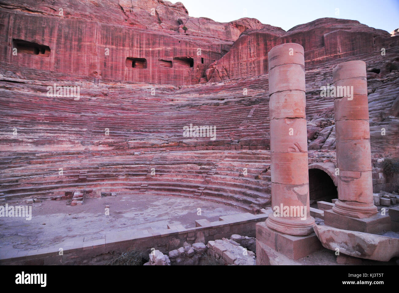 Der römischen Ära Amphitheater in die rosa Sandstein an Petra, Jordanien. die Fassaden in den Felsen gehauenen hinter sind alte Gräber. Stockfoto