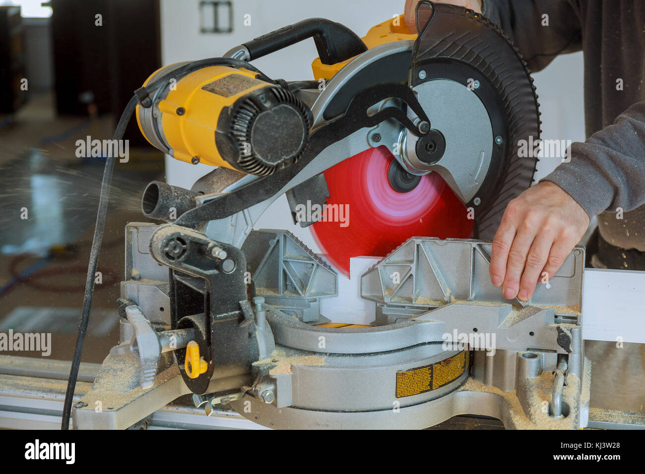 Schöner mann Tischler mit einer Kreissäge während der Installation von Holz Stockfoto
