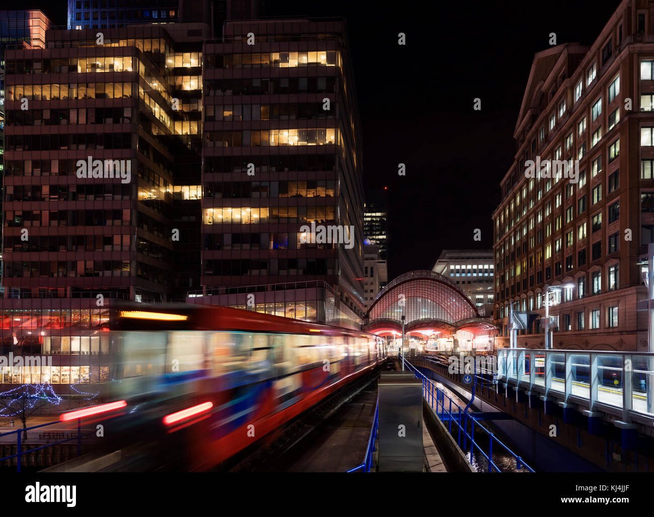 Canary Wharf Nacht Szene mit der Docklands Light Railway Mass Transit System in East London als fahrenden Zügen erfasst Stockfoto