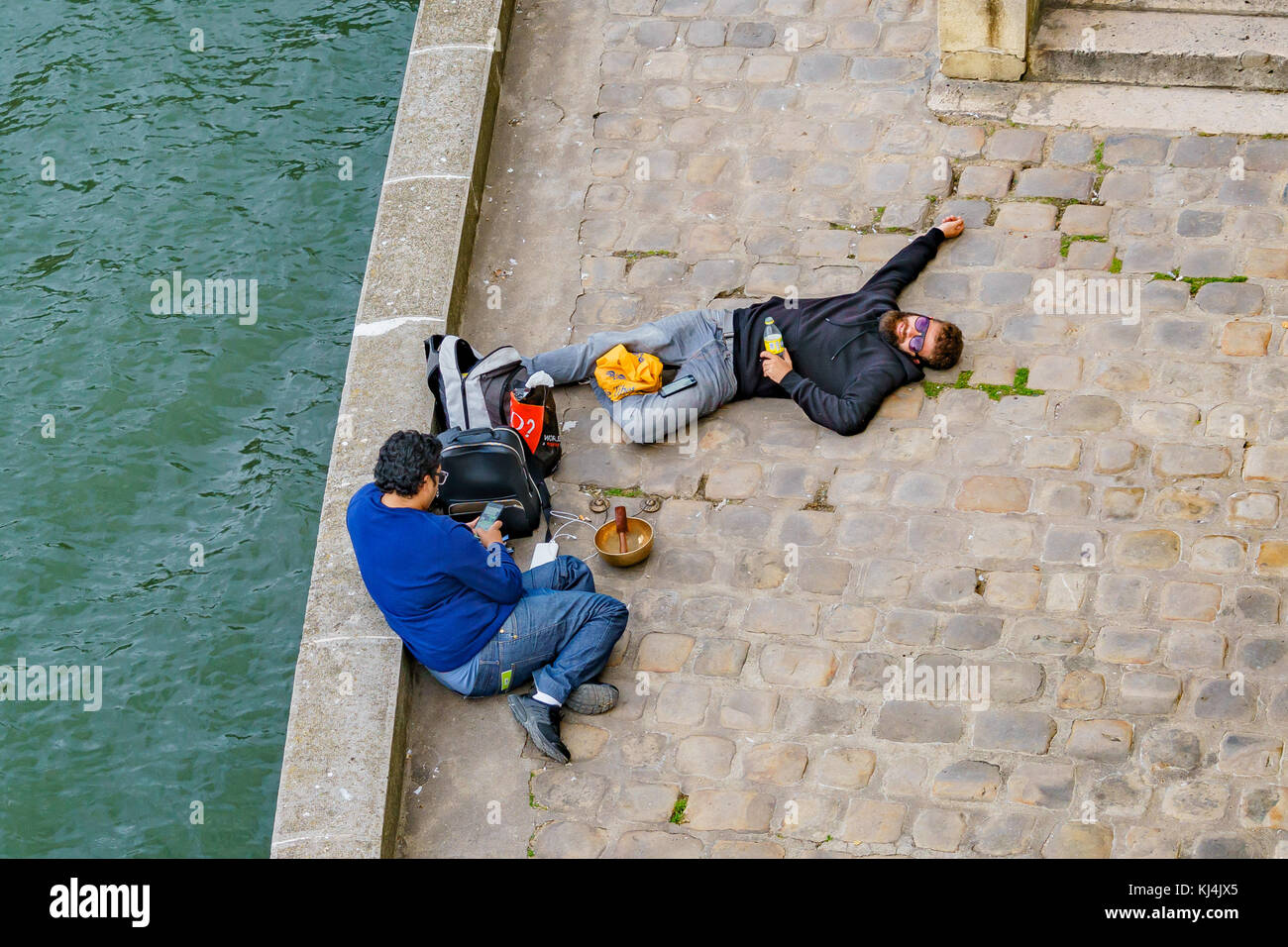 Zwei Männer entspannen neben dem Seine, Paris, Frankreich Stockfoto