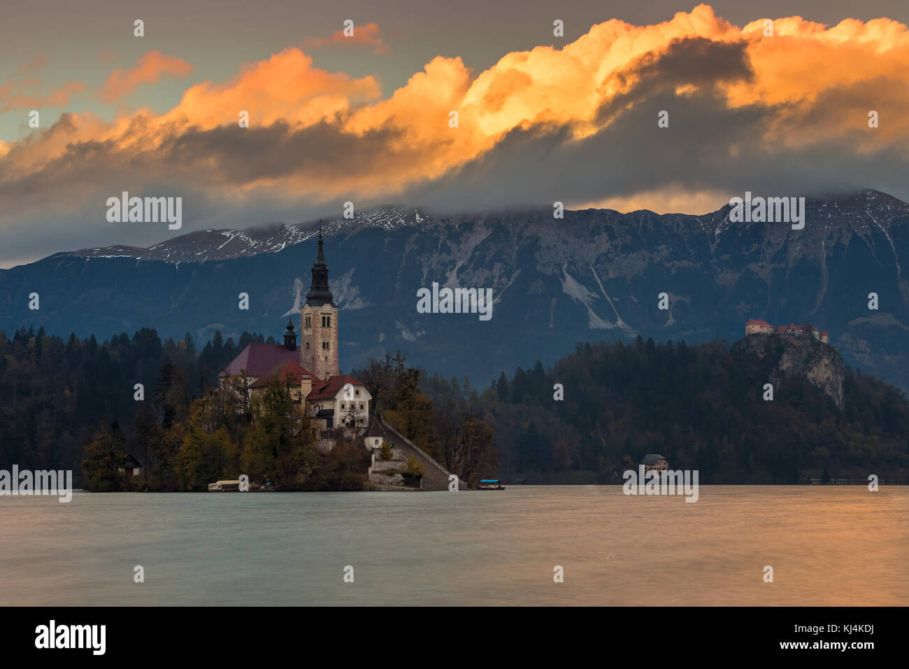 Bled, Slowenien - Schöner Herbst-Sonnenuntergang am Bleder See mit der berühmten Maria-Himmelfahrts-Kirche mit Schloss Bled und Julischen Alpen Stockfoto
