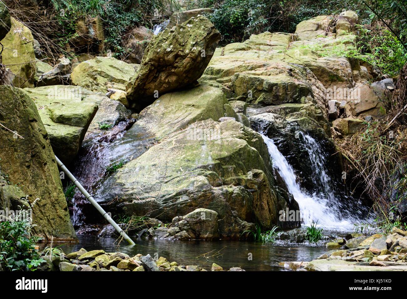 Wasser läuft Bergbach bilden einen Wasserfall zwischen den Felsen an der Moganshan, China Stockfoto