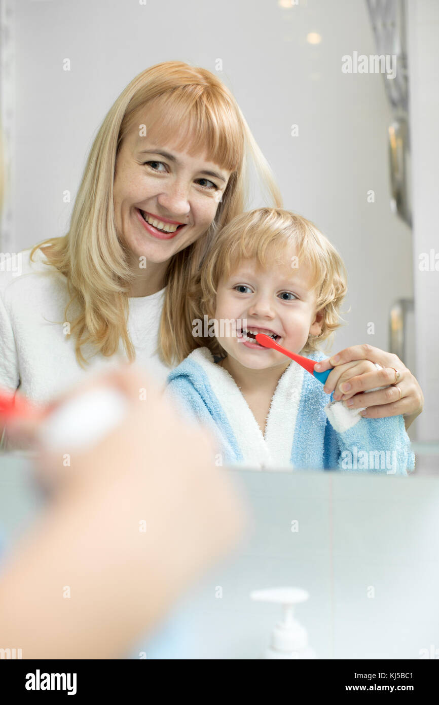 Mutter lehrt Kinder Zähne putzen Stockfoto