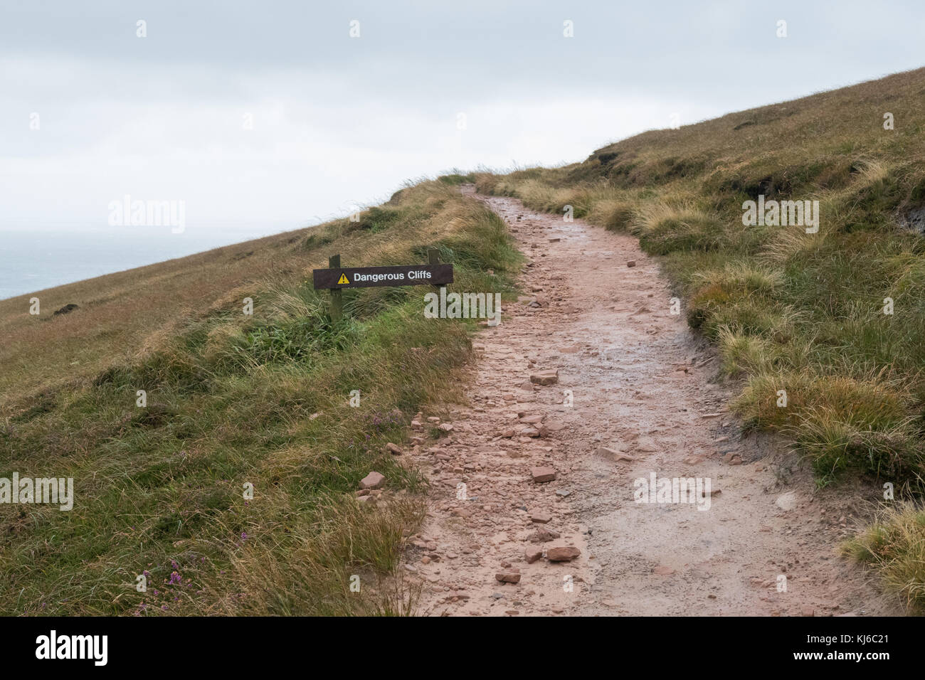 Gefährliche Klippen Schild neben Fußweg verschwinden in der Ferne, Hoy, Orkney, Schottland, Großbritannien Stockfoto