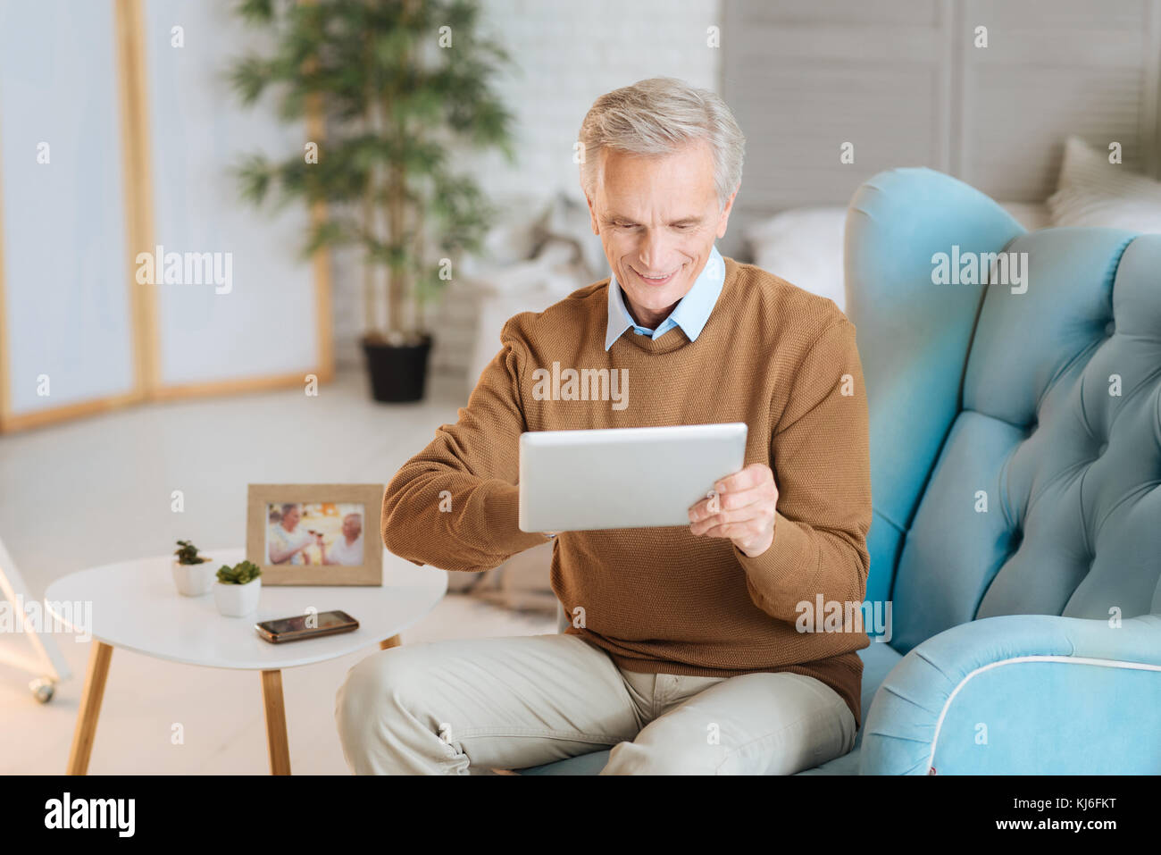 Begeistert mit seinem neuen digitalen Tablet pensionierte Gentleman Stockfoto