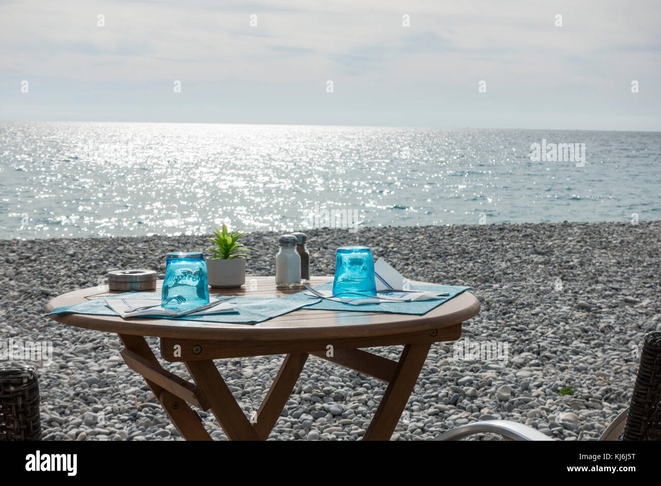 Bistro Tisch am Kiesstrand in Nizza, Frankreich. Stockfoto