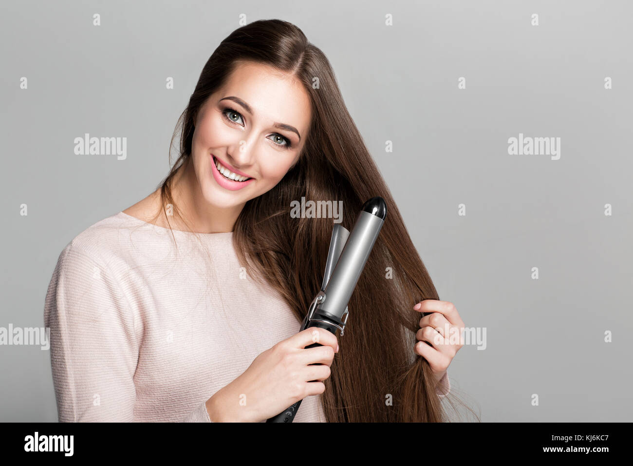 Frau mit Lockenstab. Stockfoto