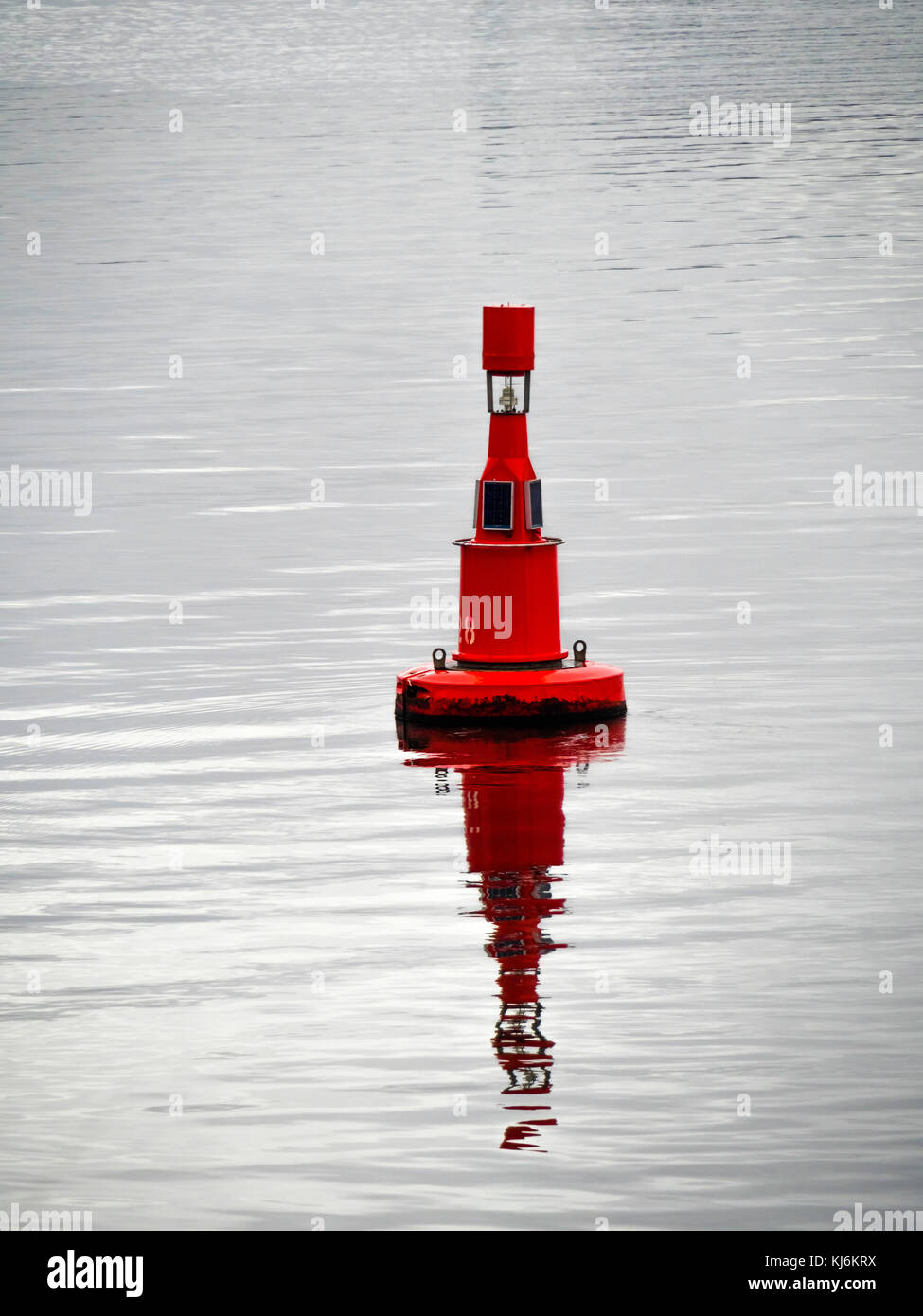 Ein roter Kanal marker Boje im Hafen von T-Stücken mit Solar Beleuchtung. Schiffe müssen Sie diese Boje an Ihre Seite, wenn der Hafen eingeben Stockfoto