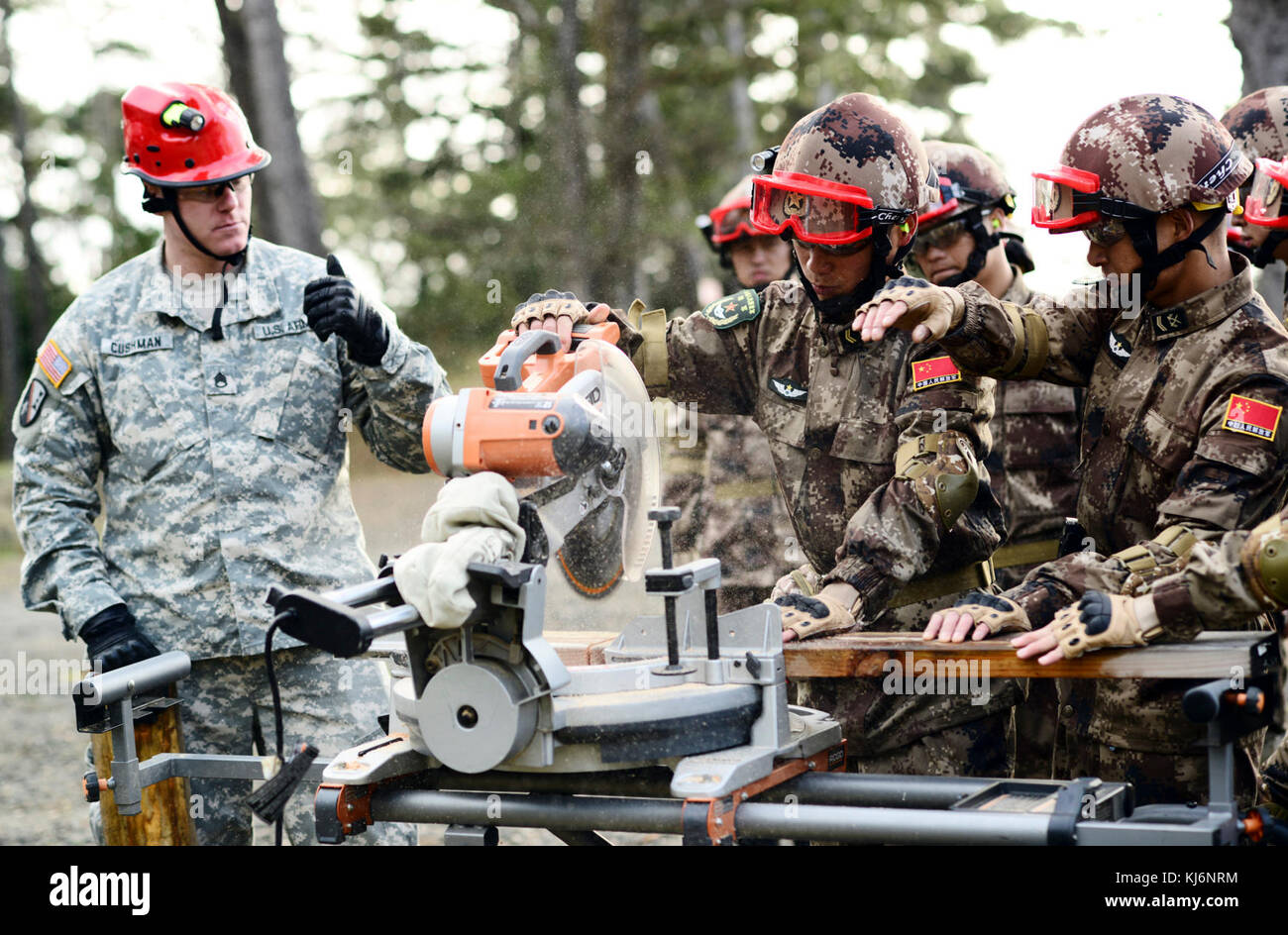 Oklahoma Army National Guard Staff Sgt. Jason Cushman, mit dem Dienstprogramm 442nd Engineer Detachment, unterstützt gemeinsame Logistik Kraft Soldaten der Volksbefreiungsarmee (PLA) mit mit einer Säge Holz für Traggerüst Strukturen im Camp Rilea Streitkräfte Training Center, 17. November 2017, in Warrenton zu schneiden, Erz Traggerüst verhindert eine beschädigte Struktur zusammenbrechen, die Retter Opfer zu extrahieren. Ingenieure von der Oregon National Guard und PLA arbeitete nebeneinander Disaster Response Funktionen gemeinsam nutzen während der 13. jährlichen US-China Disaster Management Austausch. (Foto von Sgt. Stockfoto