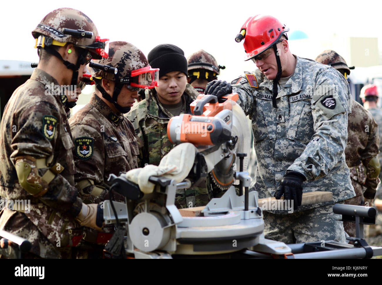 Oklahoma Army National Guard Staff Sgt. Jason Cushman, mit dem Dienstprogramm 442nd Engineer Detachment, unterstützt gemeinsame Logistik Kraft Soldaten der Volksbefreiungsarmee (PLA) mit mit einer Säge Holz für Traggerüst Strukturen im Camp Rilea Streitkräfte Training Center, 17. November 2017, in Warrenton zu schneiden, Erz Traggerüst verhindert eine beschädigte Struktur zusammenbrechen, die Retter Opfer zu extrahieren. Ingenieure von der Oregon National Guard und PLA arbeitete nebeneinander Disaster Response Funktionen gemeinsam nutzen während der 13. jährlichen US-China Disaster Management Austausch. (Foto von Sgt. Stockfoto