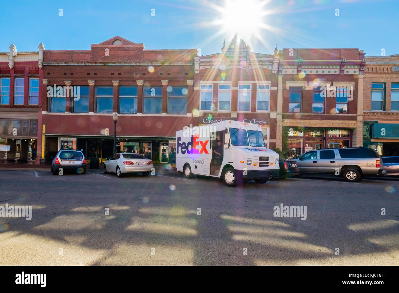 Ein FedEx delivery Truck waren die Guthrie Historic District in Guthrie, Oklahoma, USA. Starke Sonne Flare, die FedEx Lkw unterstreicht. Stockfoto