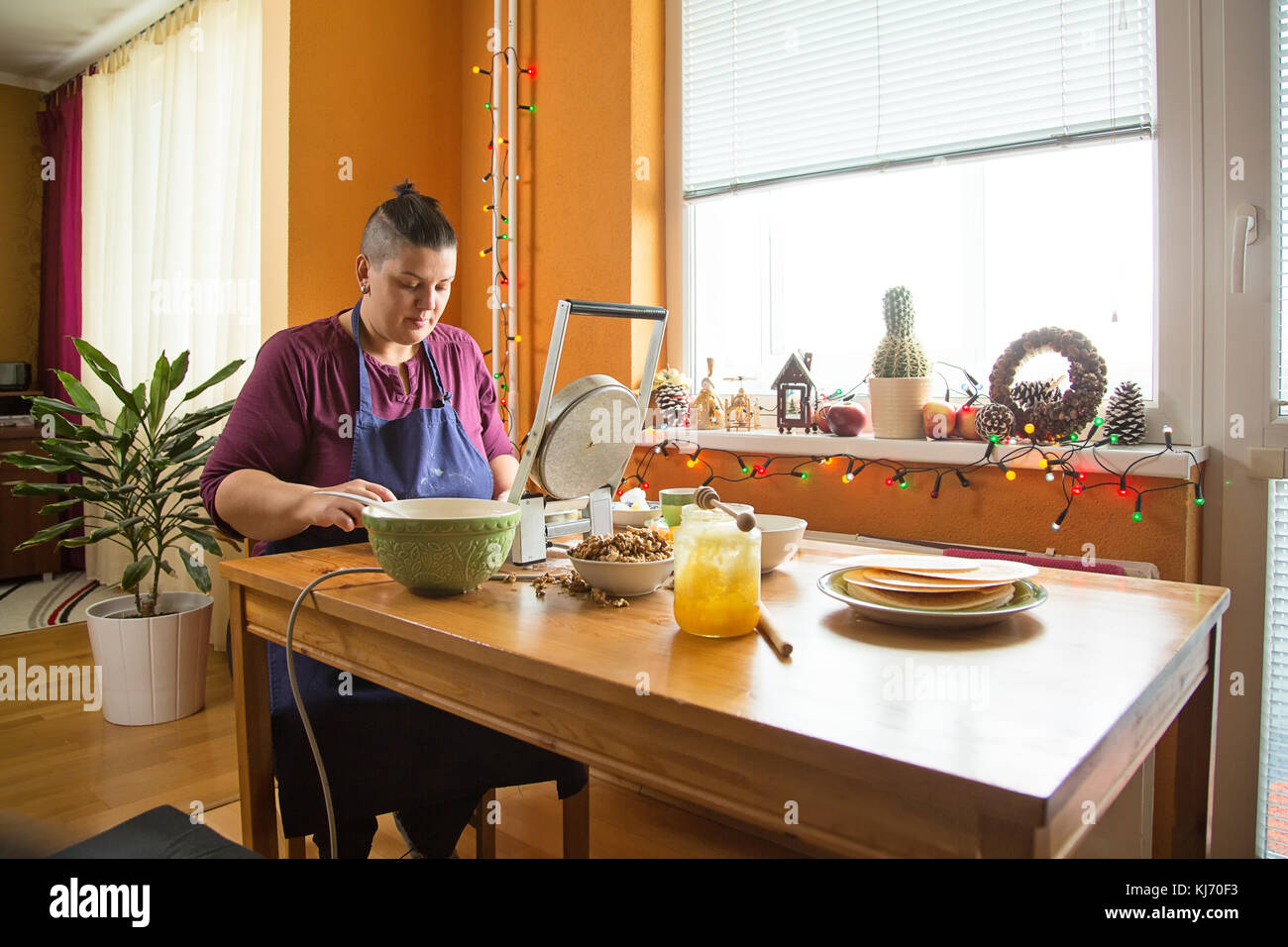 Junge Frauen, die traditionellen slowakischen Weihnachten Wafer, serviert vor Weihnachten Abendessen. Frau sitzt in der Küche, hinter einem Tisch, mit Ingr Stockfoto