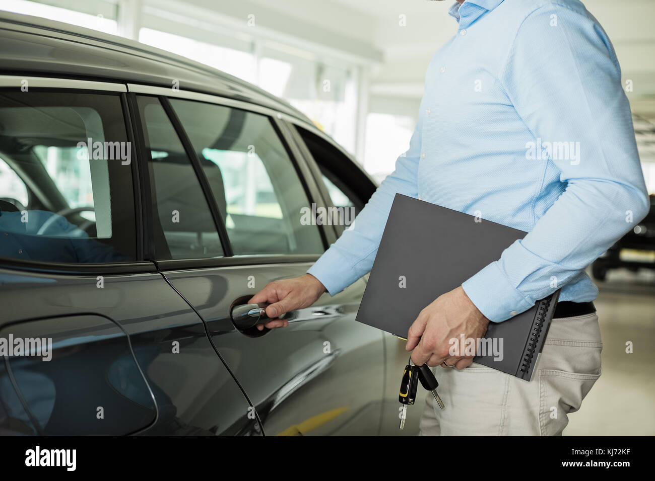 Nahaufnahme Foto des Menschen Öffnen einer Fahrzeugtür, halten ein Auto  Türgriff mit einer Hand und Ordner und Autoschlüssel in der anderen Hand  Stockfotografie - Alamy
