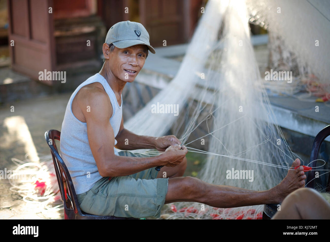 Vietnamesische fischer Instandsetzung seiner Fischernetz in einem Dorf an der Küste Stockfoto
